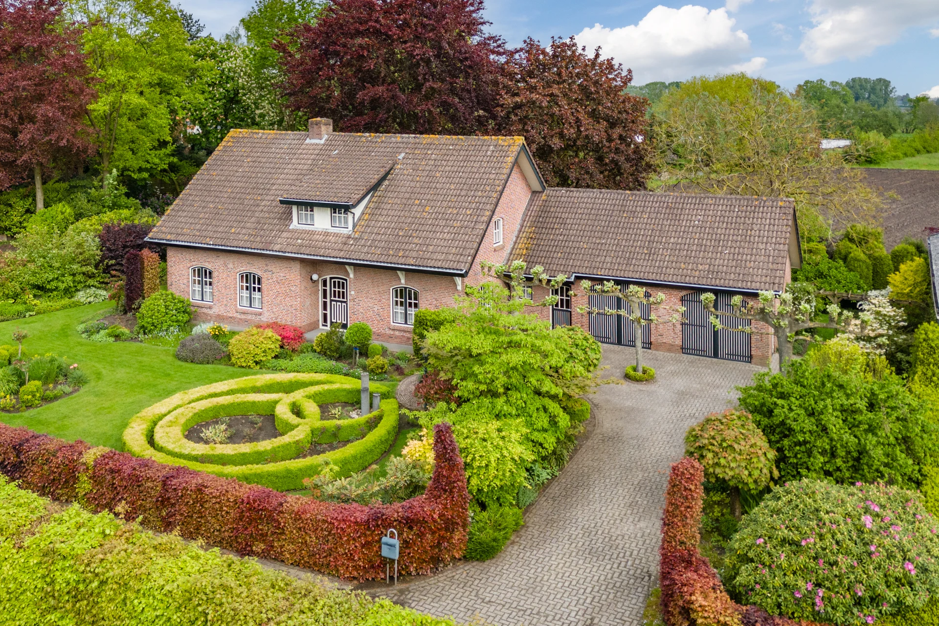 Drone photo of a country home with an outbuilding and landscaped garden