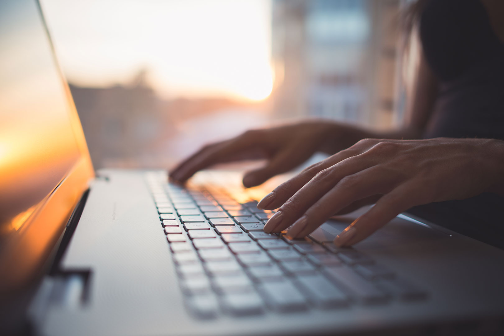 A copywriter working on a property description on a laptop
