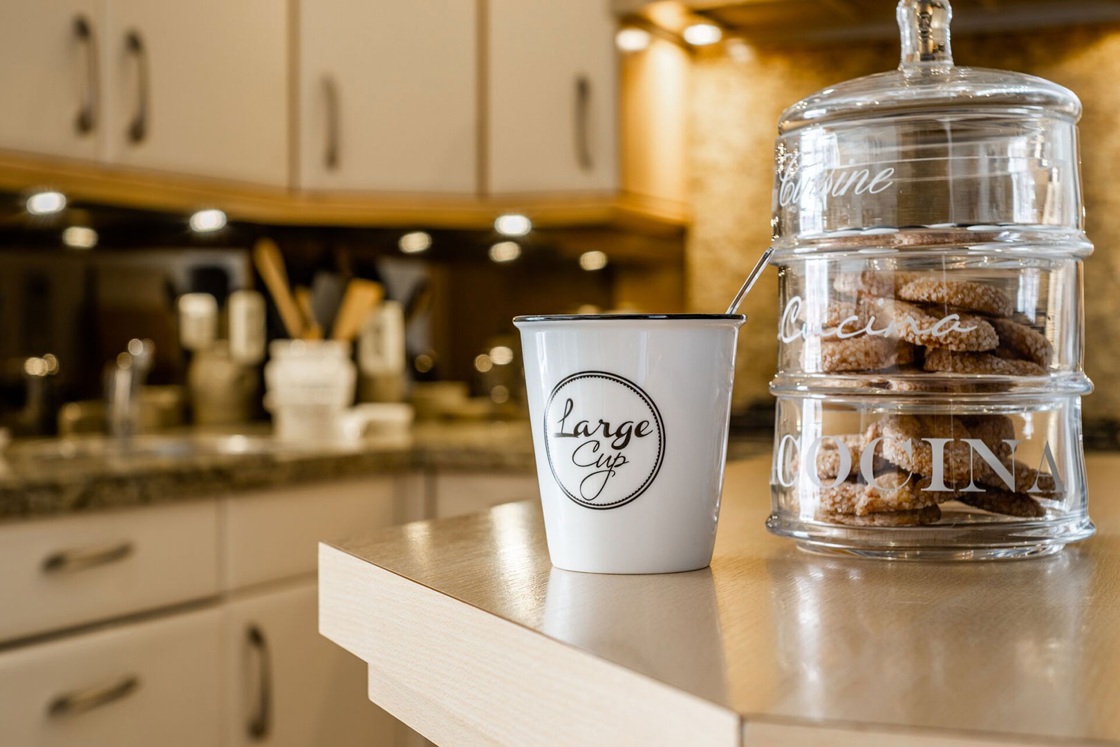 Atmospheric detail of coffee and a glass biscuit jar in the kitchen
