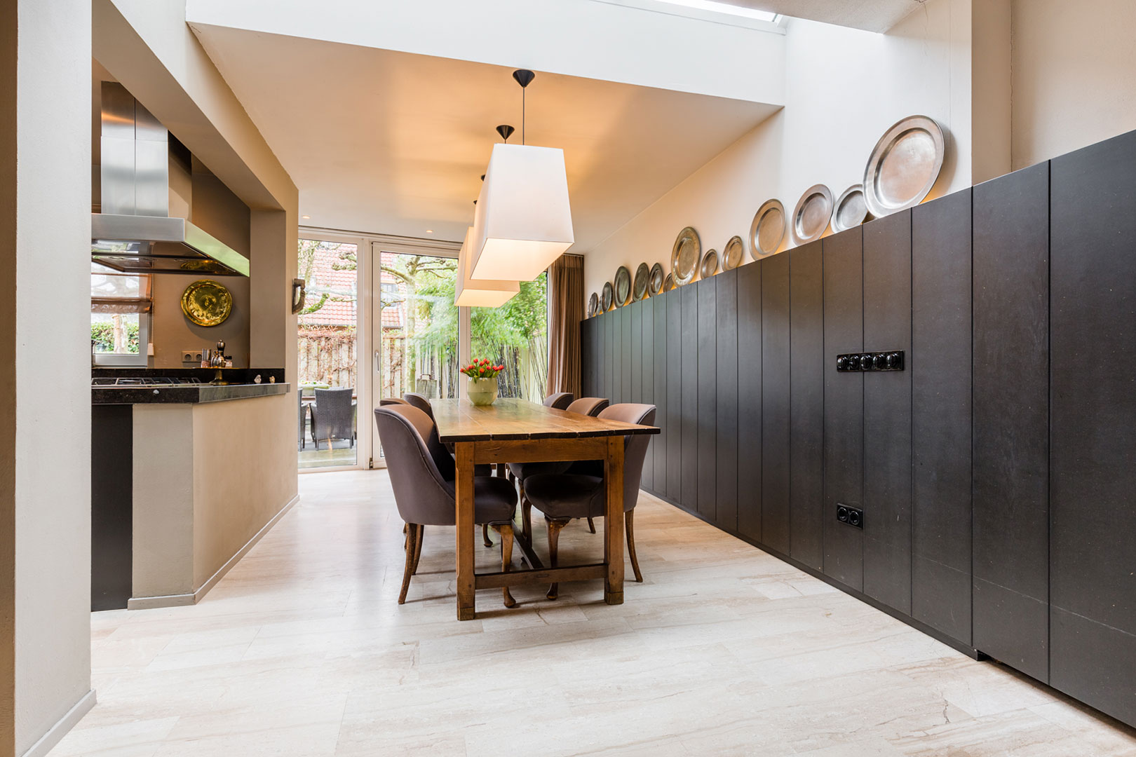 Spacious kitchen-diner with dark cabinets and a wooden dining table