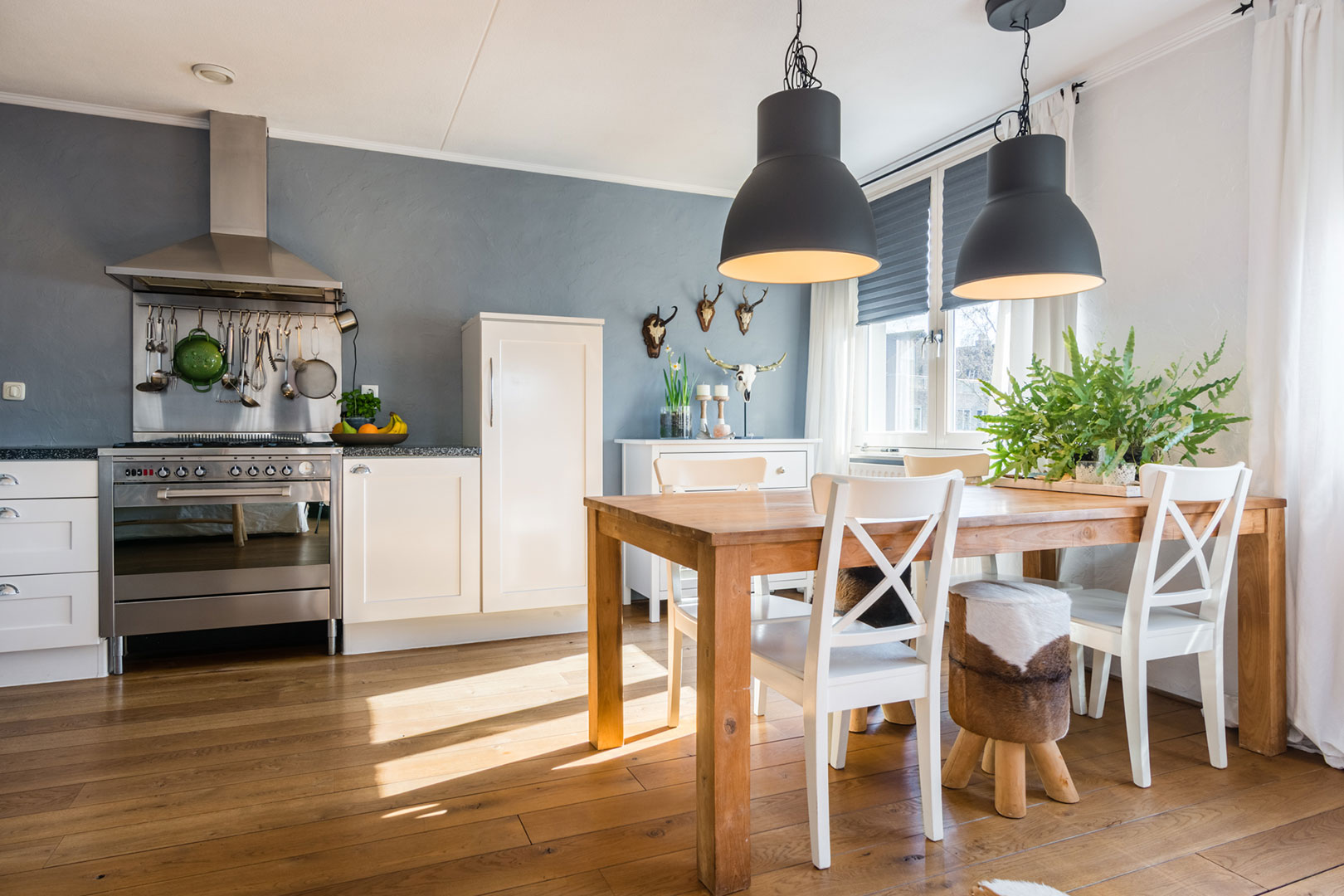 Country kitchen-diner with a wooden table and black pendant lights