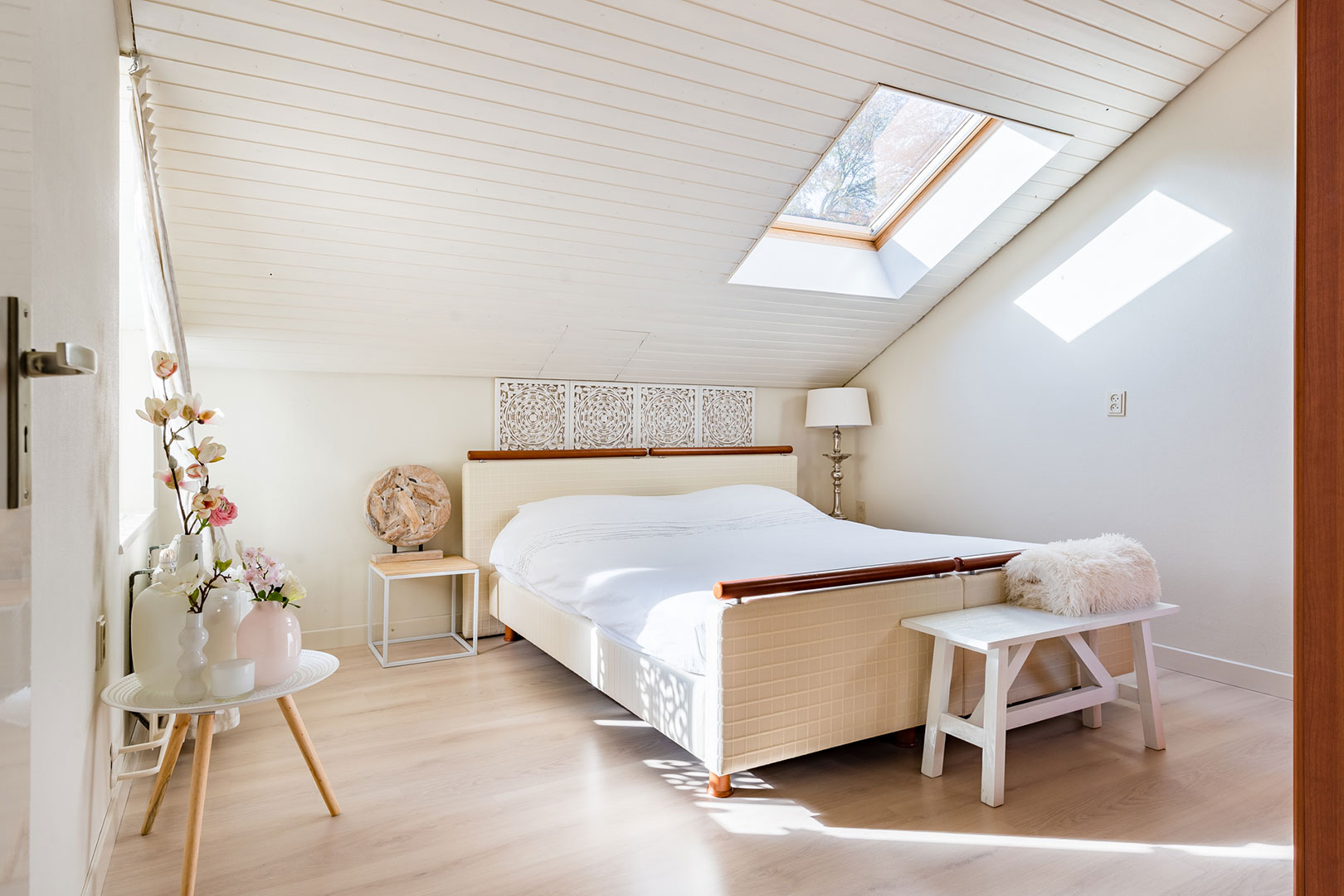 Sunny bedroom beneath a sloping roof with a skylight