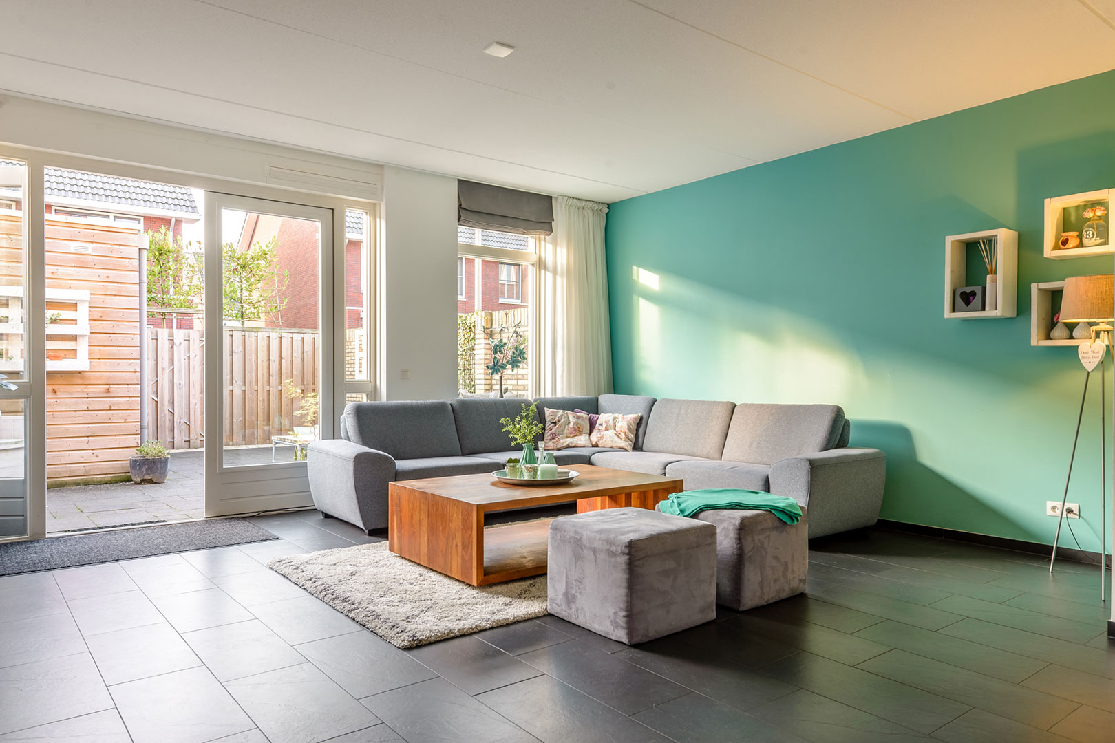 Living room with a green feature wall and French doors to the garden