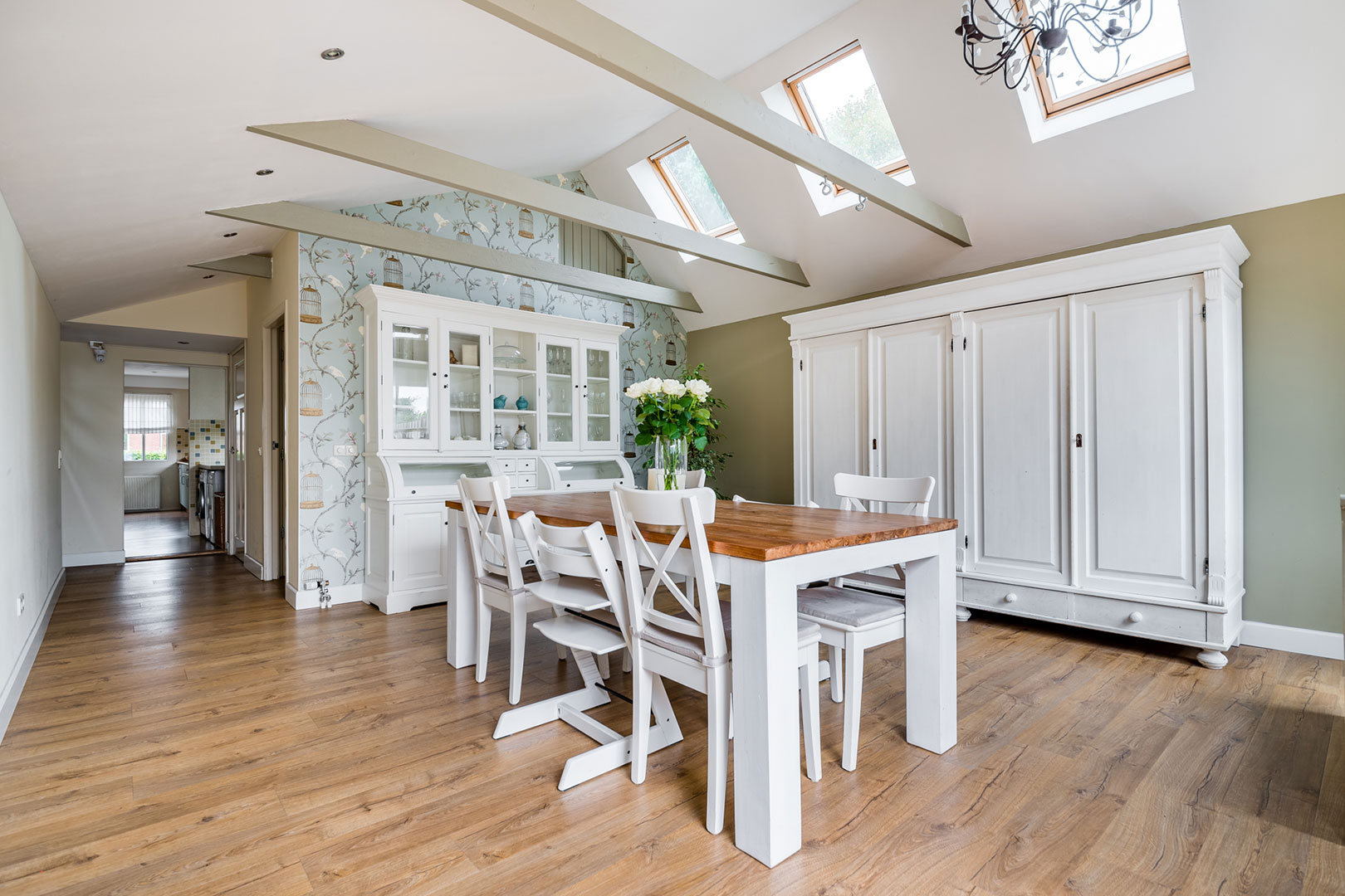 Bright dining room beneath a high ceiling with skylights