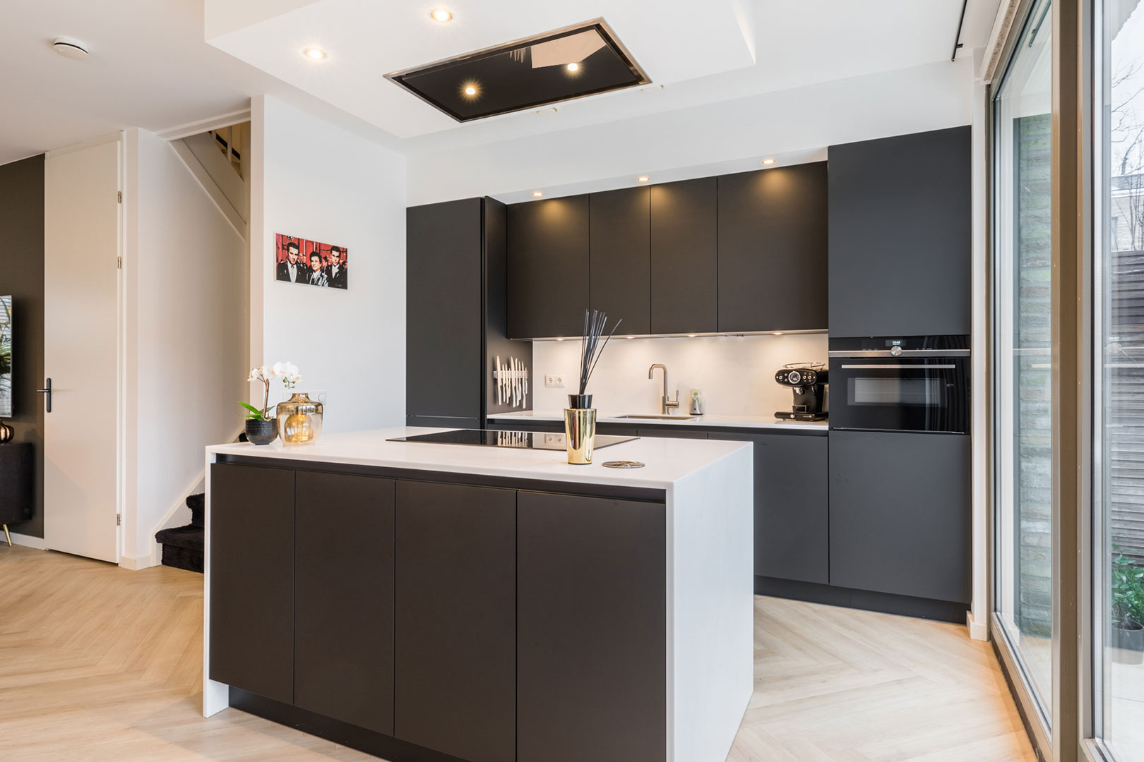 Sleek black kitchen with an island and sliding glass doors