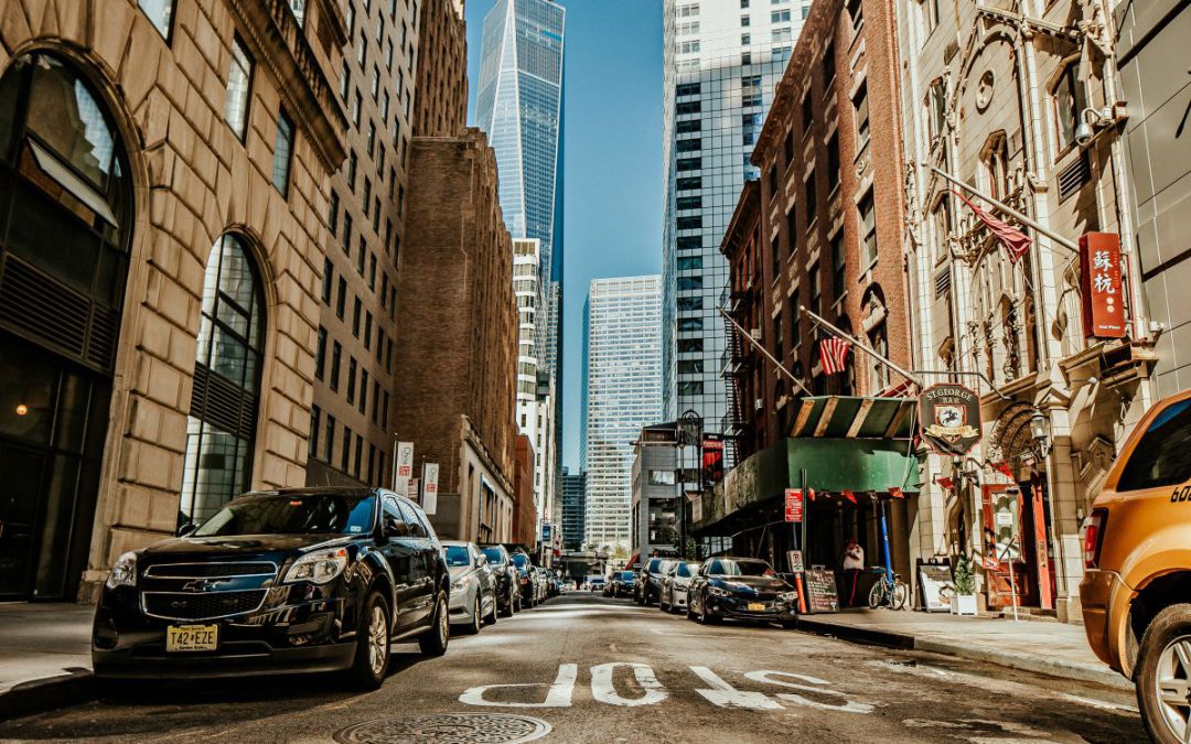 Straatbeeld in een moderne stad met hoge gebouwen en geparkeerde auto’s, geschikt voor vastgoed- en stadsmarketing